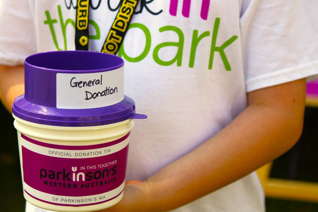 A child holds a general PWA donation tin